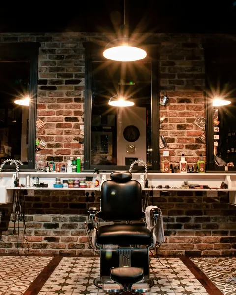 An empty barbershop chair under warm lights