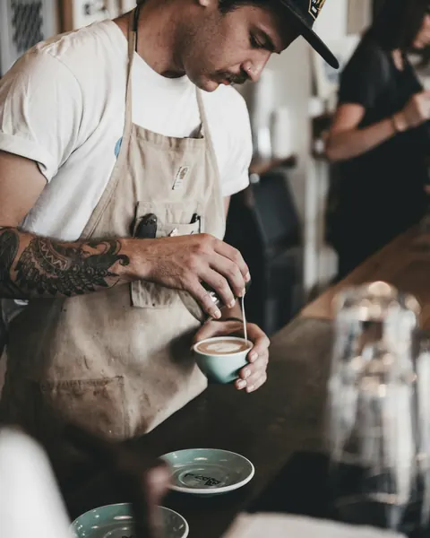 A barista pouring latte art